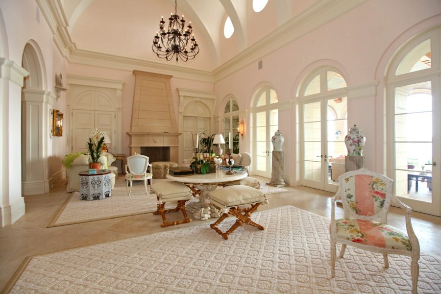 Main Living Room with precast stone fireplace and barrel vaulted ceiling with operable round windows above plaster crown view of covered rear loggia doors.