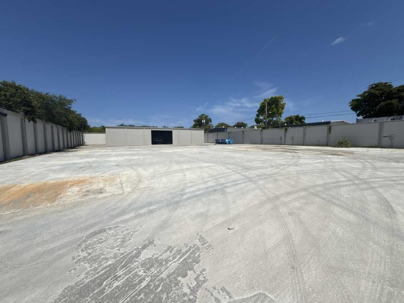 A freshly renovated two-story commercial building showcasing a complete commercial build-out Pompano Beach project, complete with clean asphalt parking, a new paint job, and upgraded site features.